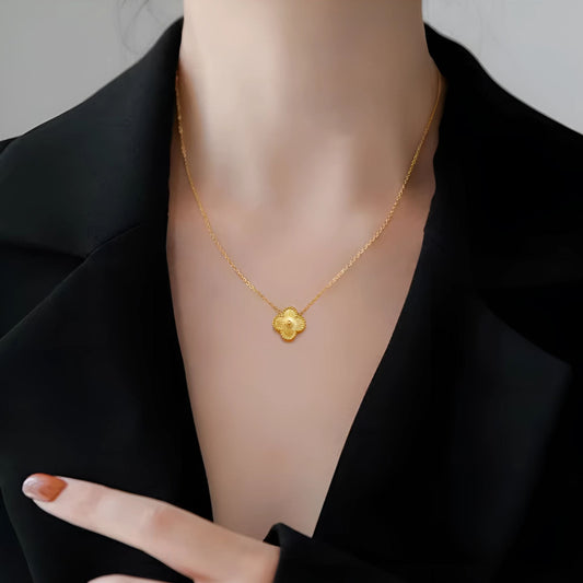 Woman wearing a clover pendant necklace with a light summer dress.