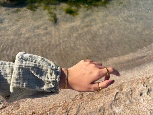 Golden jewelry pieces stored in a soft pouch for summer care.