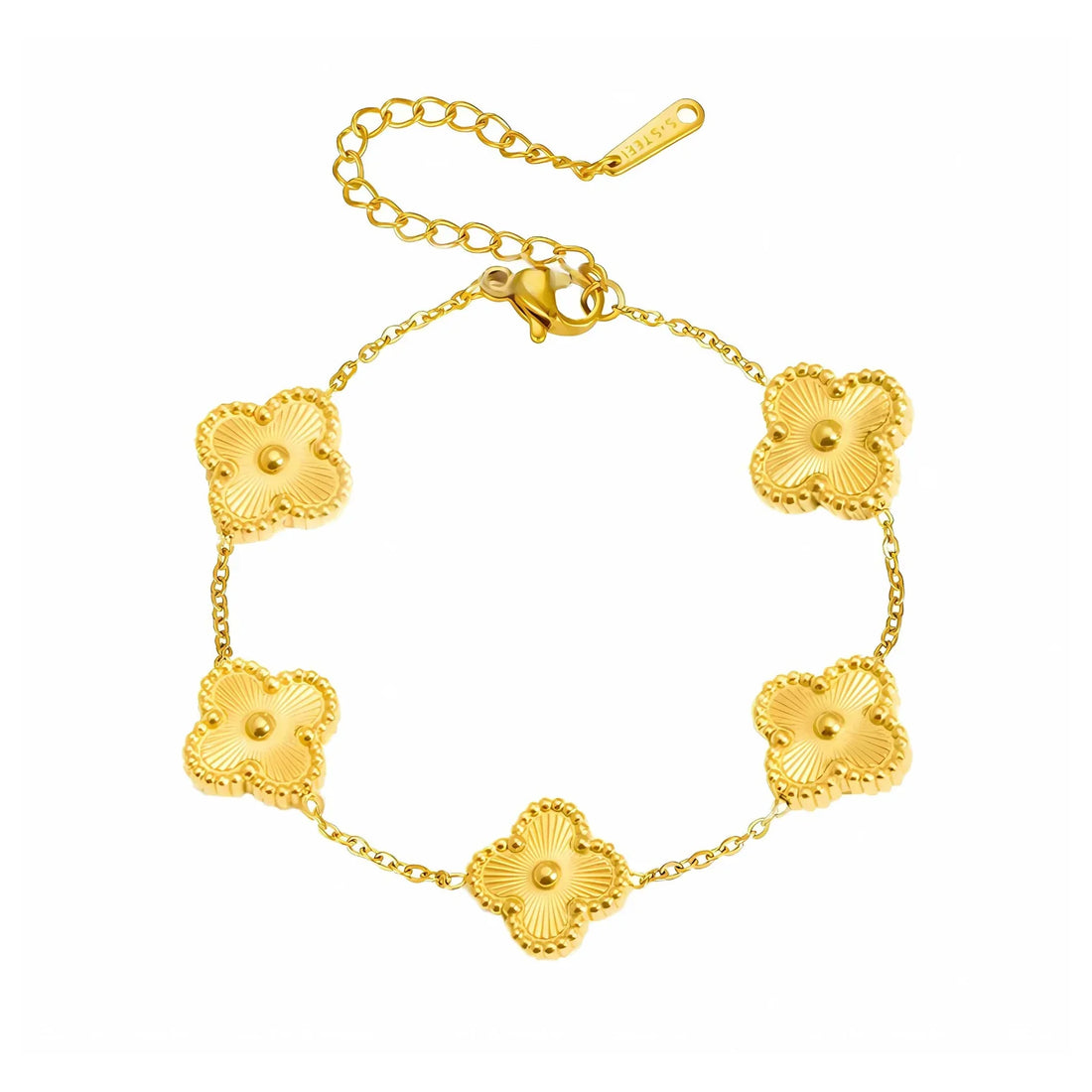 Gold chain bracelets stacked on a woman’s wrist in a minimal outfit.