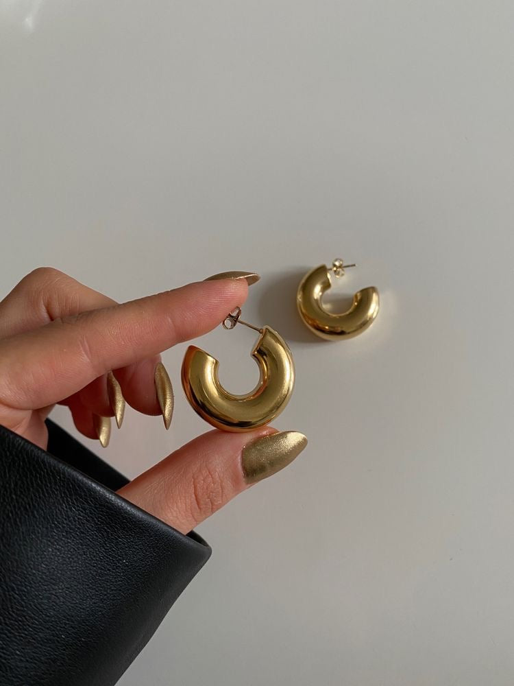 Gold hoop earrings styled with a sleek black dress.
