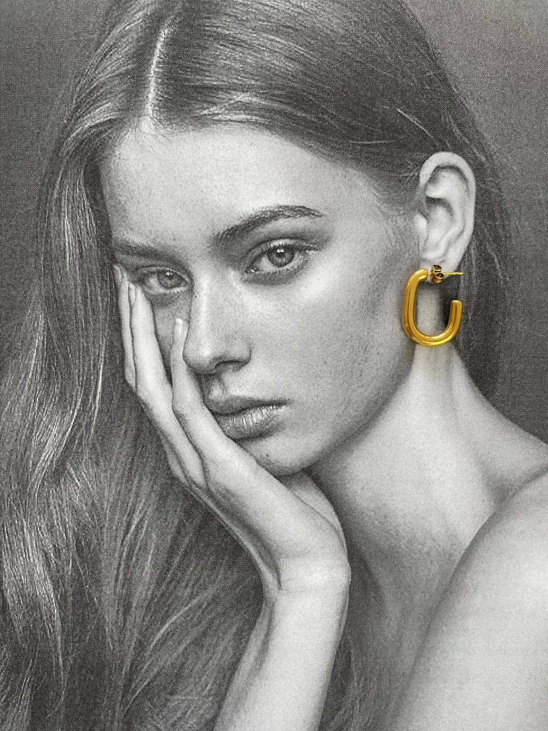 Minimalistische goldene Kette und Ringe auf neutralem Hintergrund stilvoll arrangiert.