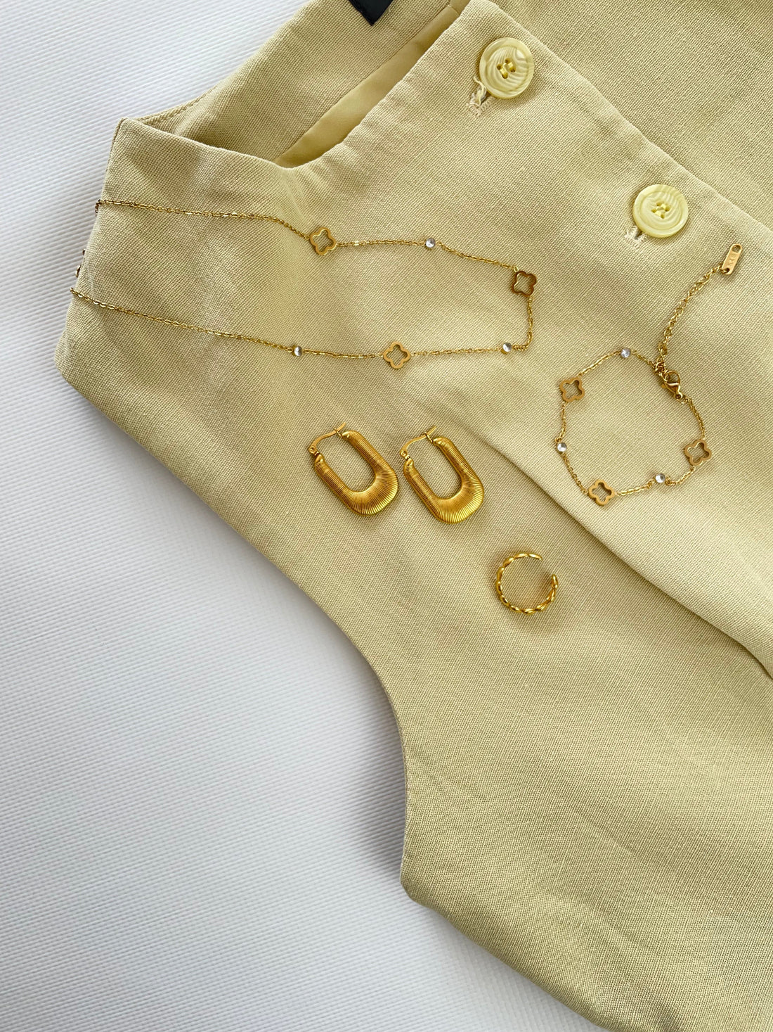 Minimalistische goldene Kette und Ringe kombiniert zu einem eleganten Büro-Outfit.