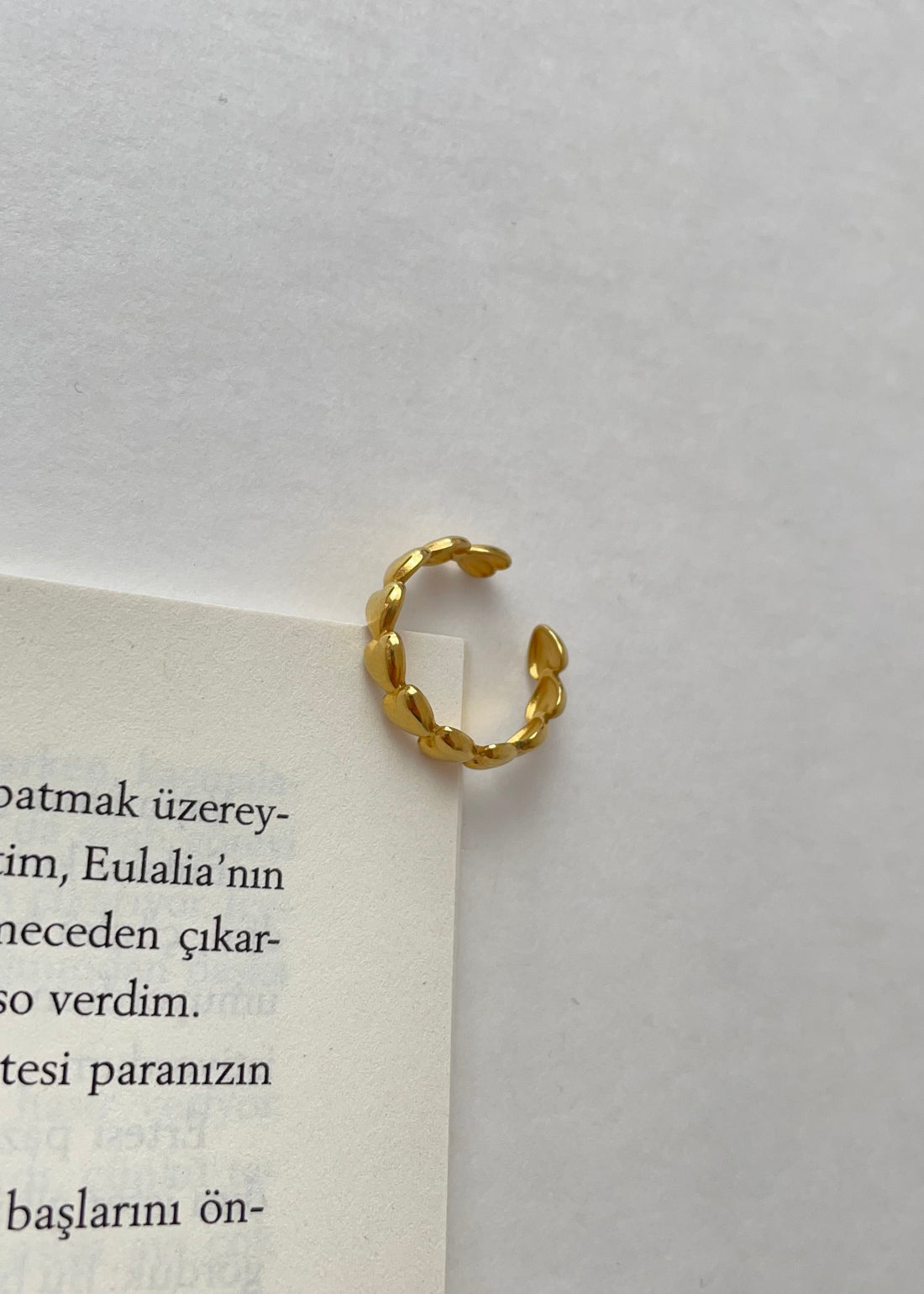 Hand mit mehreren vergoldeten Ringen im minimalistischen Stack-Look.