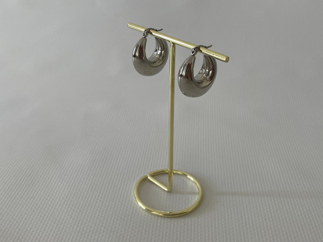 Woman wearing medium-sized silver hoop earrings with a casual white shirt.