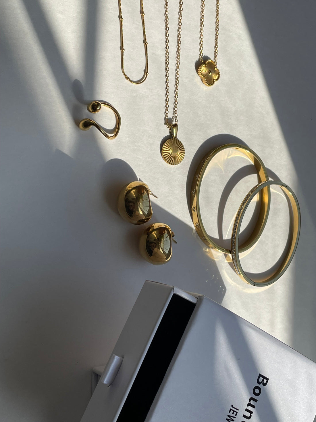 Frau trägt mittelgroße silberne Creolen zu einem weißen Hemd im Alltagslook.